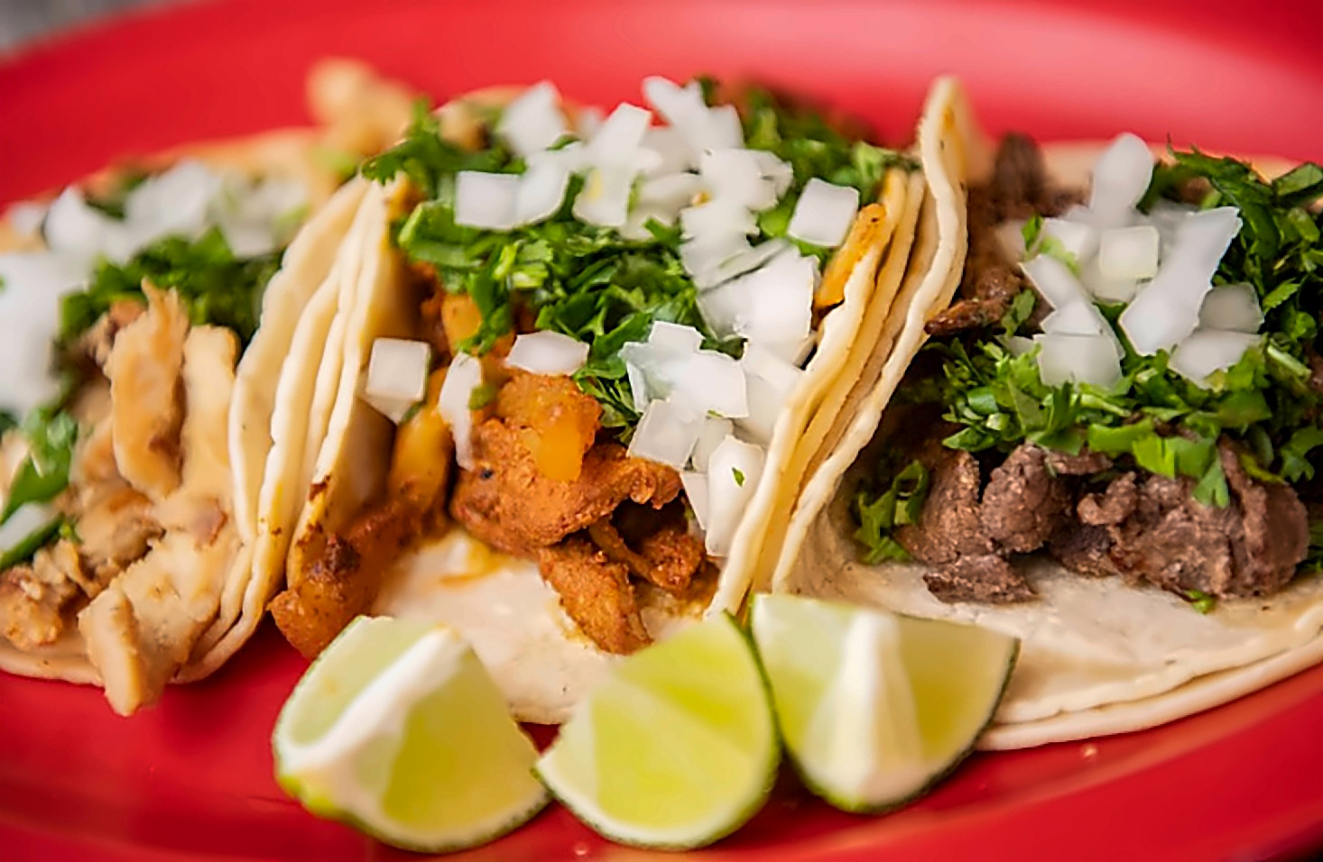 Chicken, al pastor and steak tacos with lime